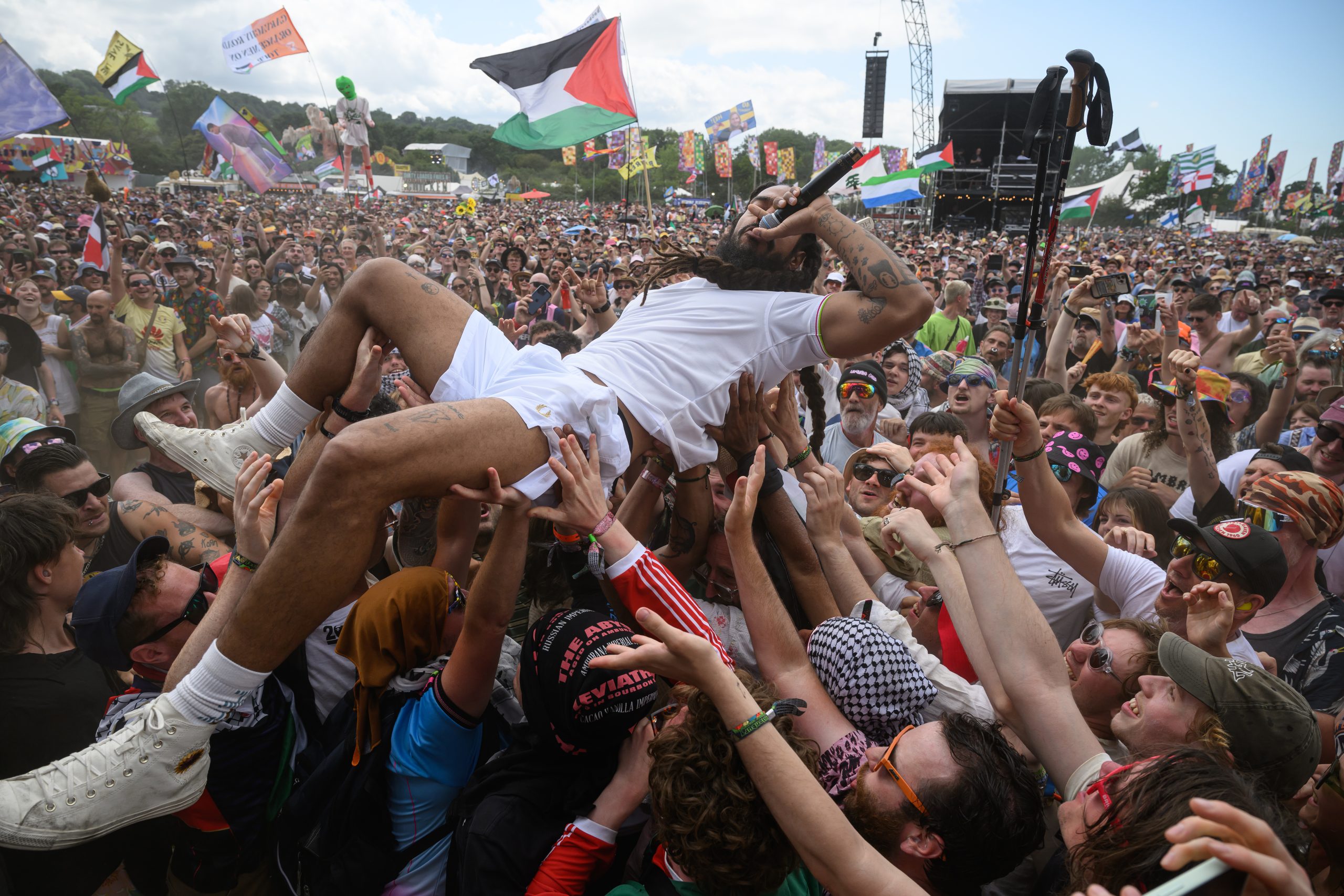 U.S. Visa Revoked for Colorado Woman Over Antisemitic Comments at Glastonbury Festival; Talent Agency Cuts Ties with Group Involved; BBC Apologizes for Not Removing Controversial Chant from Livestream
